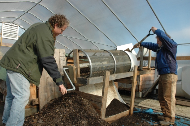 ECO City Farms staffers harvested materials at Community Forklift to build this compost sifter. Here, apprentice Matthew turns the crank, while senior technical adviser Benny Erez, right, shovels compost into the device.